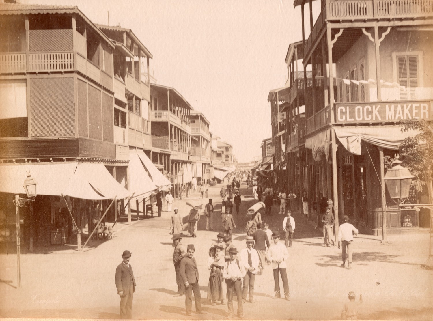 Photograph of a street in Port Said (Rue de Commerce), Egypt, late 19th century, showing people wih Arab, Turkish and Western styles of dress.