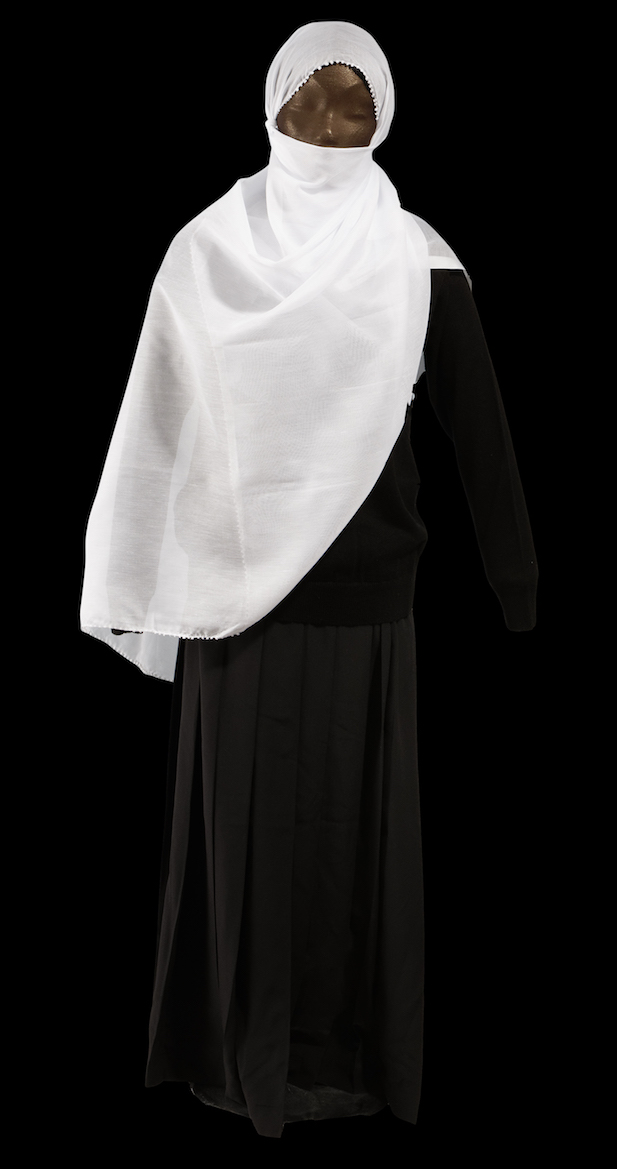 Outfit for an initiated Druze woman, consisting of black jumper and skirt, with a white veil. TRC 2000.0052 (veil), TRC 2000.0064 (jumper), and TRC 2000.0071 (skirt). Click the illustration for the TRC catalogue entry for the white veil. A Druze woman, Lebanon.