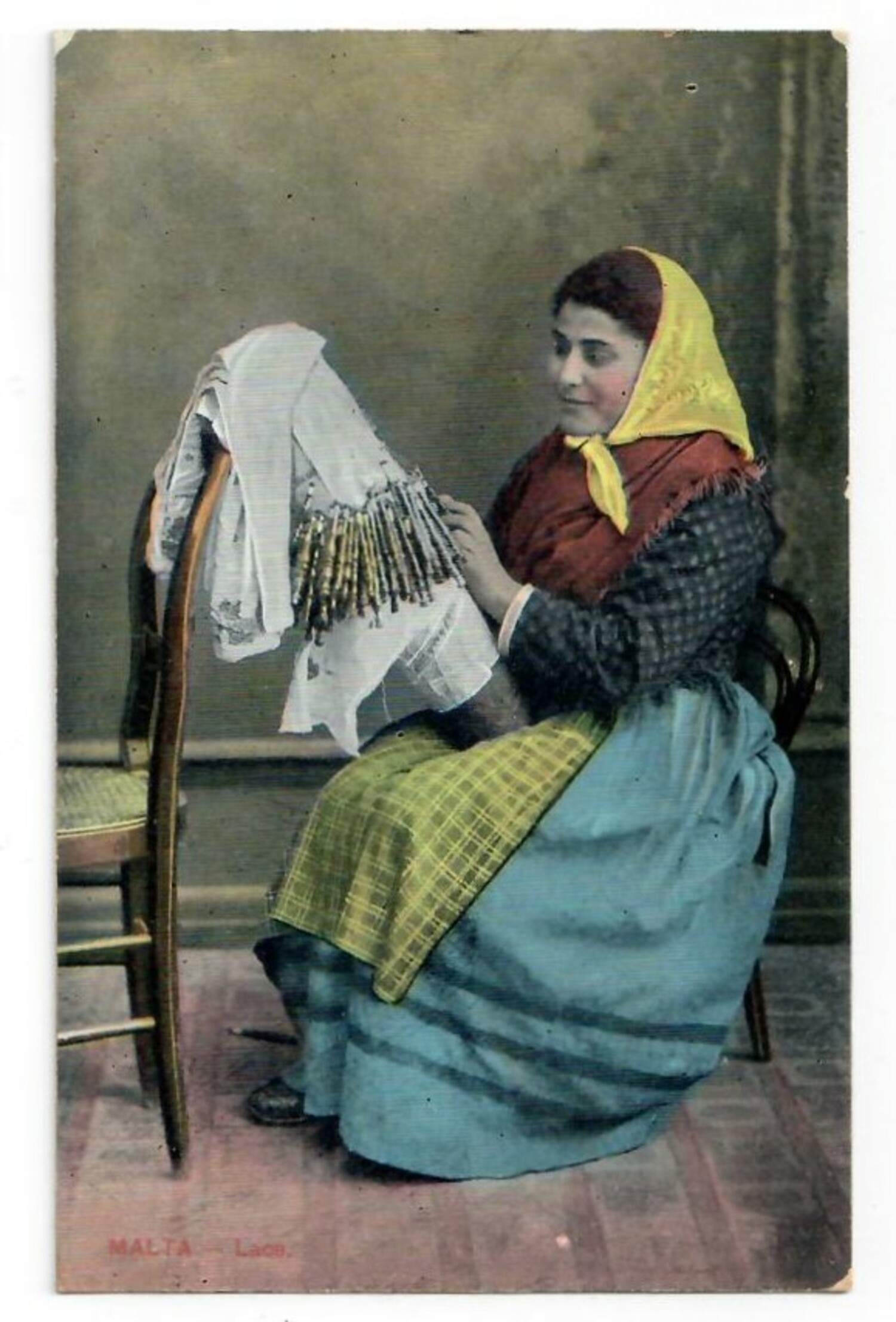 Coloured postcard with a Maltese woman making lace (TRC 2020.4905).
