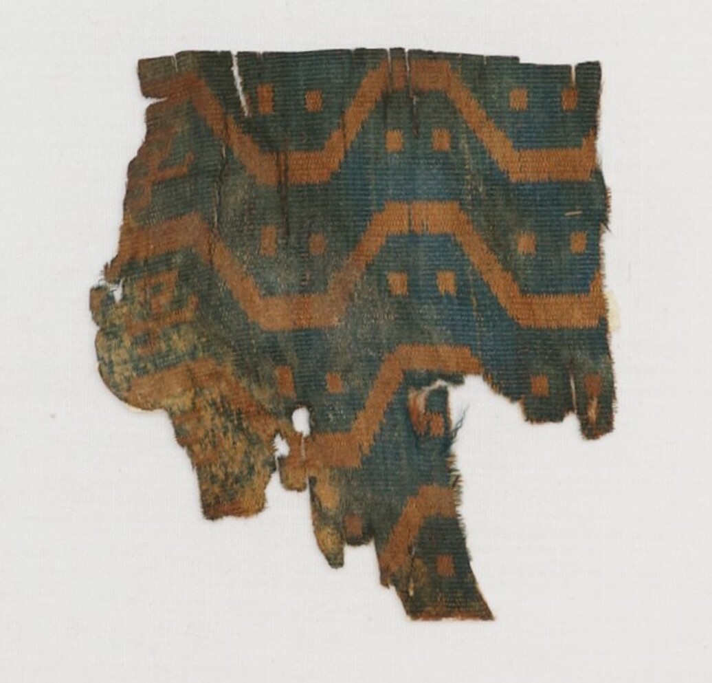 Silk cloth fragment with traces of woven Chinese characters (TRC 2000.0009).
