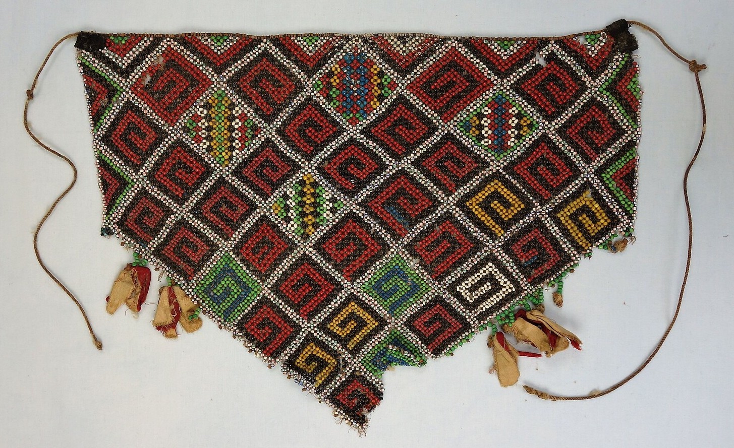 Fig. 2. A triangularly shaped apron made from glass beads in various colours, which are used to create simple, geometric patterns. New Guinea, Indonesia, 1930s (TRC 2016.0998).
