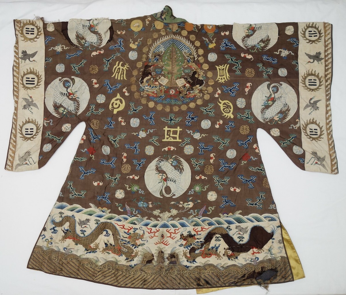 Fig. 6. Back of a gown in dark brown with woven designs of flying red-headed cranes and smaller motifs including circles, clouds, flowers and bats. China, 19th century (TRC 2018.2841).