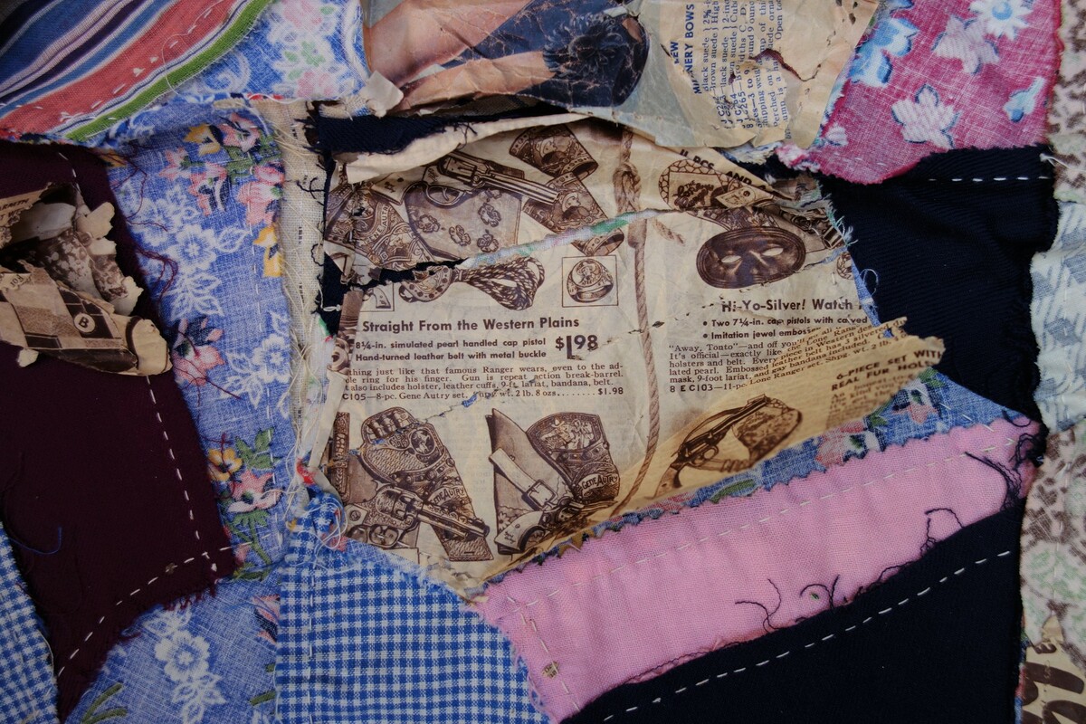 Detail of the pieced quilt, showing pages from the Sear Roebuck catalogue (TRC 2018.3129).