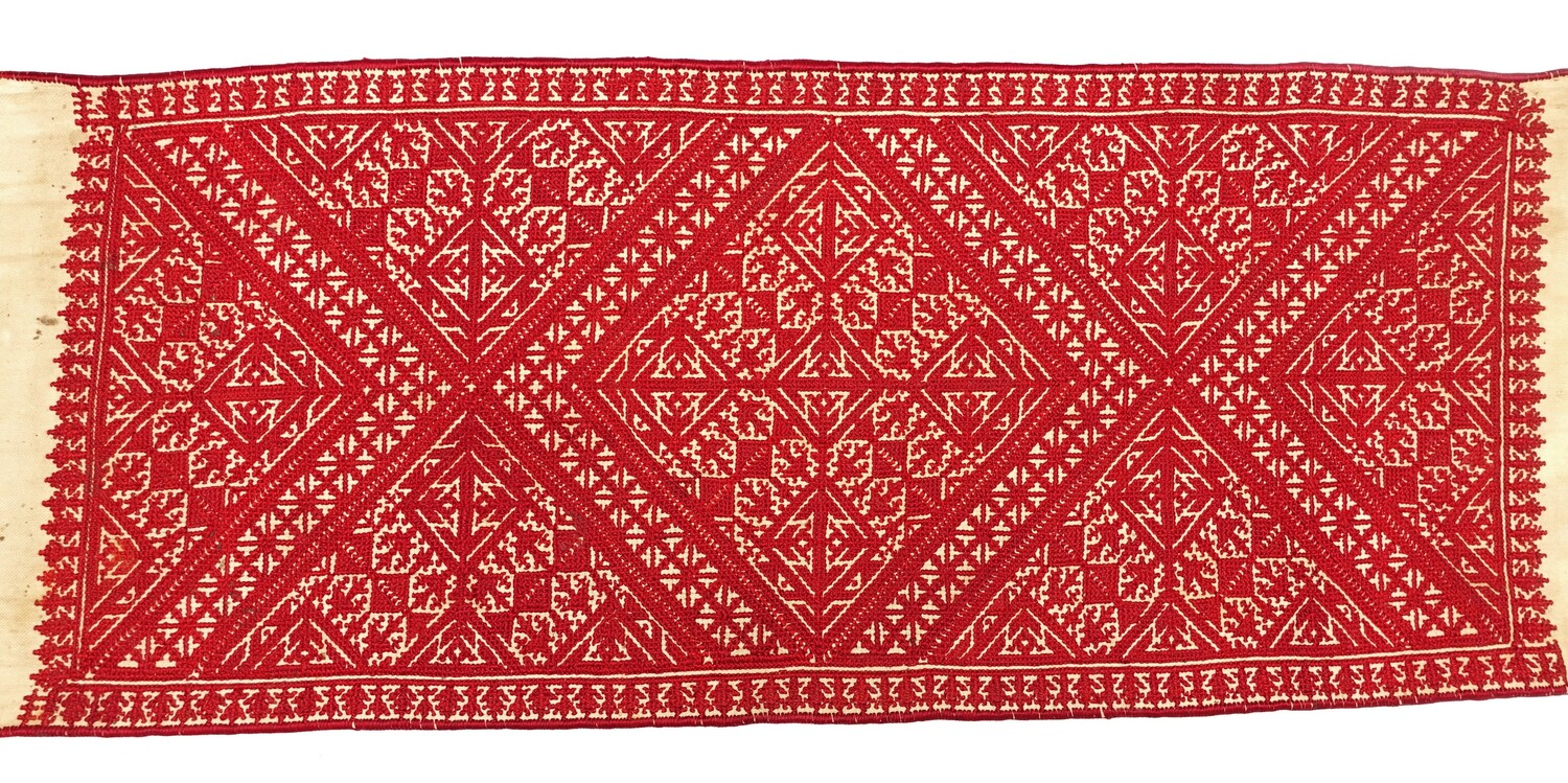 Lang, katoenen paneel met een zich herhalend, gecompliceerd geometrisch patroon in rood op een witte achtergrond. Fes, Marokko, 20ste eeuw (TRC 2022.0956).