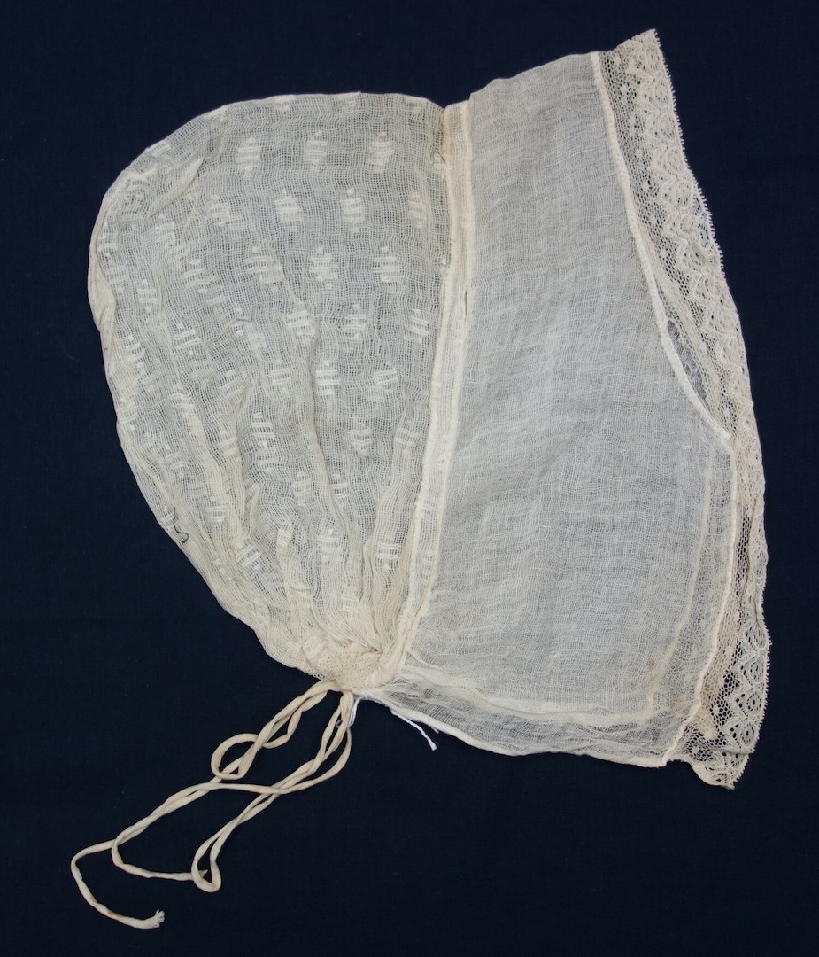 Lace cap made from a fine, open weave cloth with individual motifs of paired lines and dots darned into the ground. Rijnland (?), the Netherlands, 19th century (TRC 2024.1177).