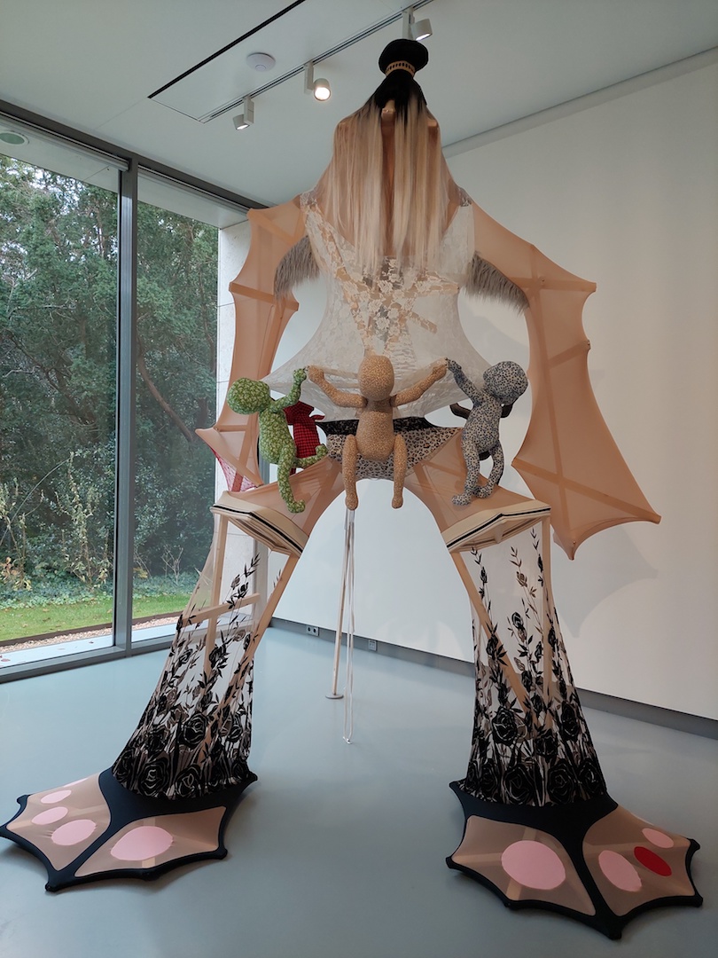 Who Saves Who?, textile sculpture by Lara Schnitger, 2024. The giant female figure protects both babies and nature, as she stands with her feet rooted in the earth (note the green between her toes). Photograph by S. Anderson 