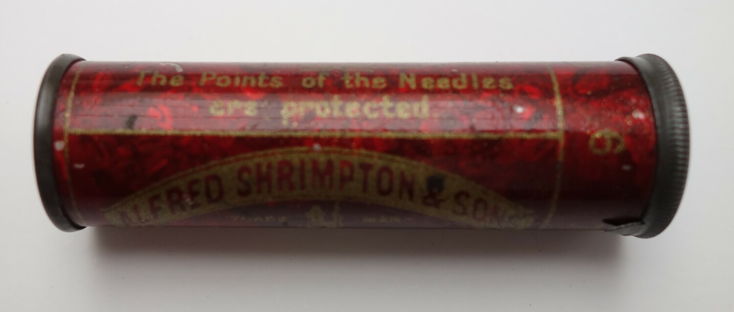 Round red metal case containing needles. The packaging has the text: ALFRED SHRIMPTON & SONS, REDDITCH. UK, 1890-1900 (TRC 2025.0672).