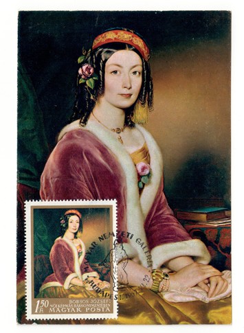 Postcard of an Hungarian painting by Borsos Jóseph, showing a woman wearing a red velvet jacket  with the same image on an Hungarian postage stamp (TRC 2018.2544).