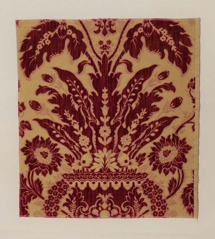 Sample of Genoese cut velvet with a voided ground and a design of large stylised flowers, including sun flowers. The pattern is based on the fabric originally woven for the throne room of the royal palace in Madrid (Charles III, r. 1759-1788). The modern replica has been used for the throne room's restoration (TRC 2018.3021).