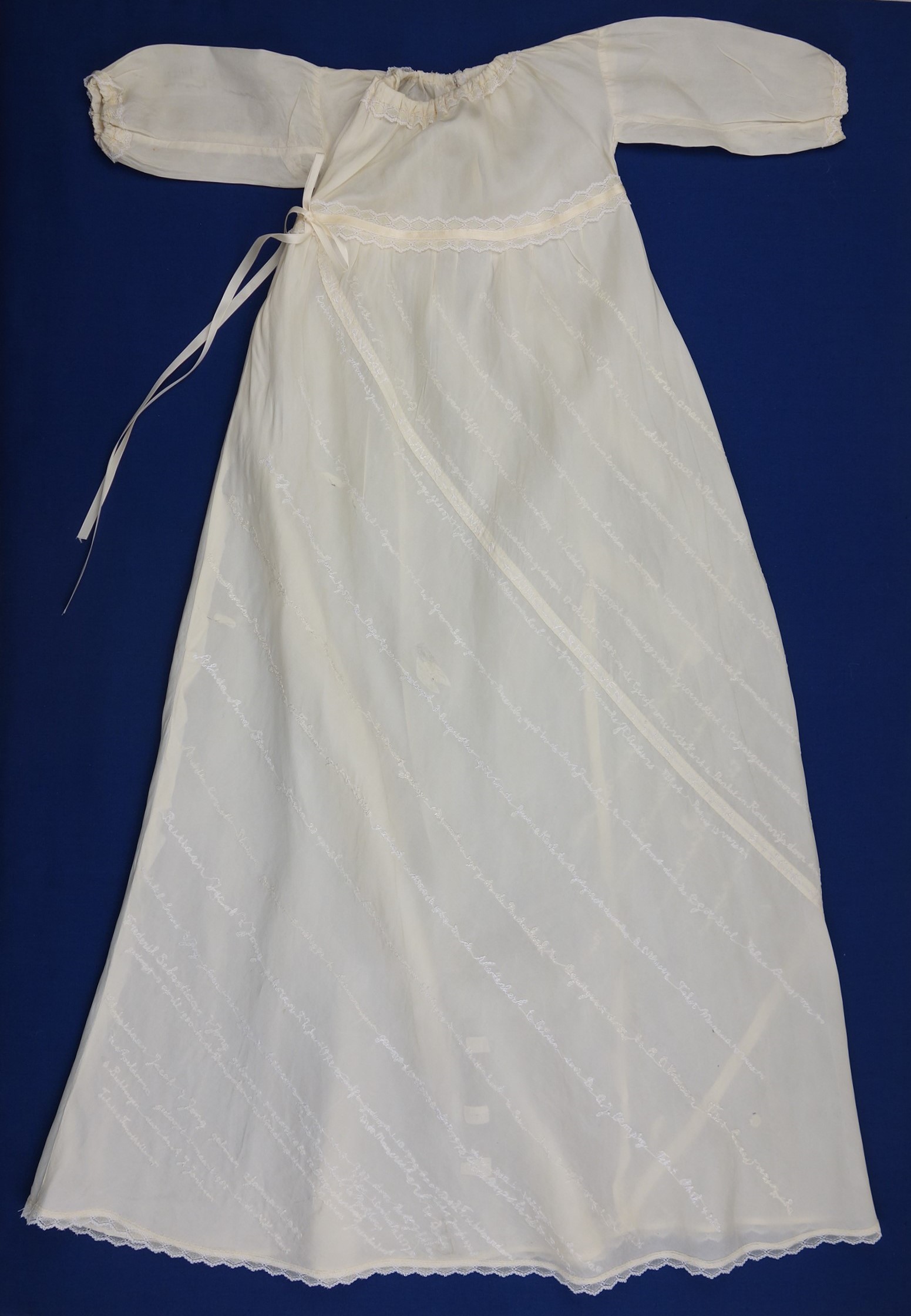 Christening gown from 1947 made from parachute silk, embroidered with the names of seventeen young children who were baptised in the gown, between 1947 and 2013 (TRC 2010.0070a)