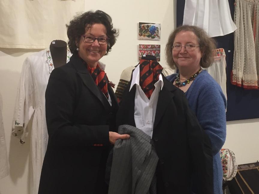 Moniek van Sandick overhandigt een kostuum van de 3 Oktober Vereeniging aan Gillian Vogelsang, directeur TRC.