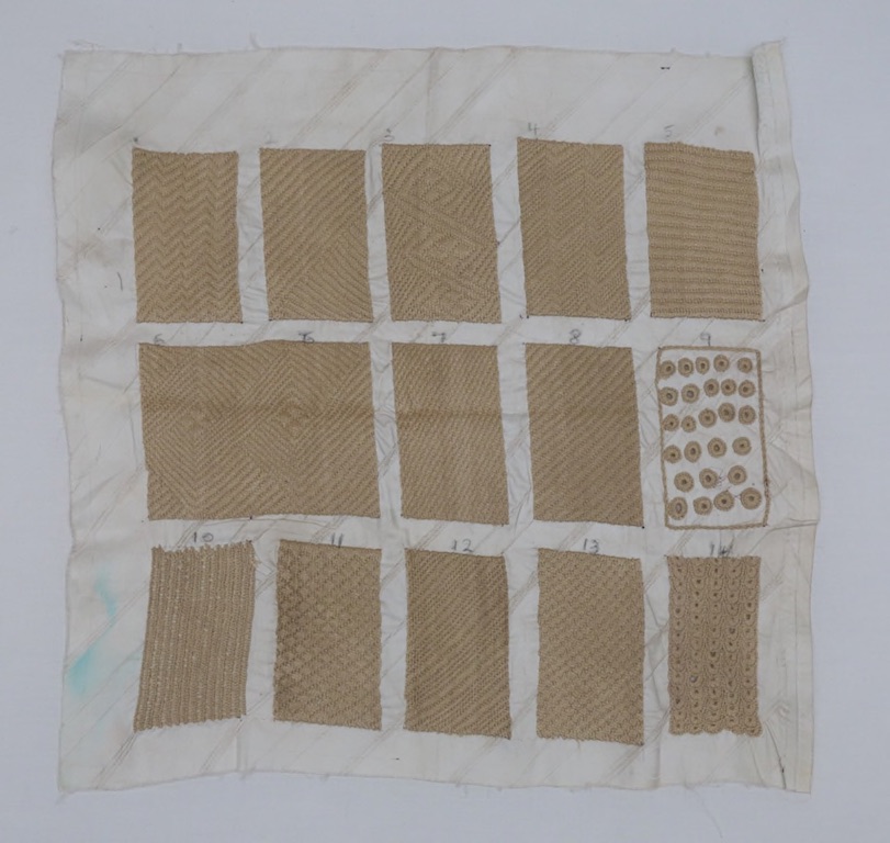 Sample of white damask cloth with fourteen embroidery patterns, Queen Amina Embroidery group, Nigeria, 2019 (TRC 2019.0097).