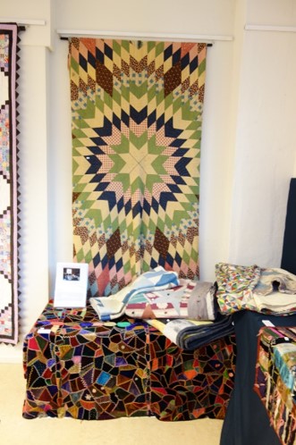 Hanging down the wall, a Star Burst quilt from the 1860's. 